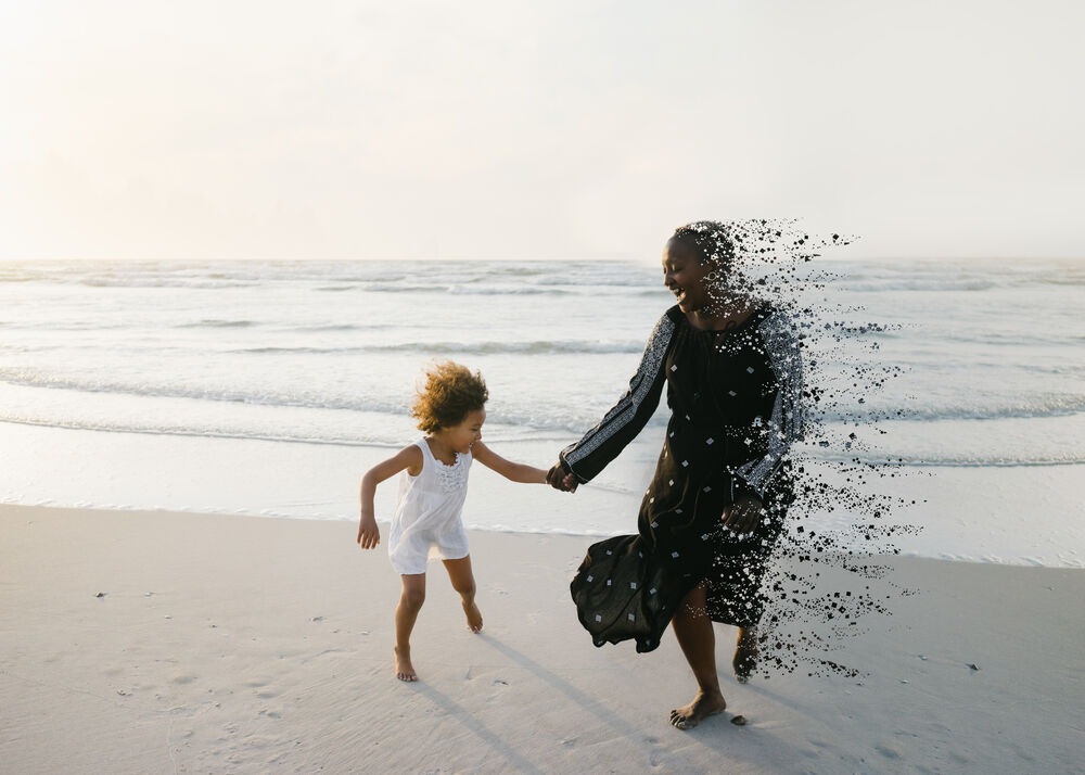 Photo of mother and daughter running on the beach, the mother is slowly disintegrating and turning into pixels on the right-hand side of her body.
