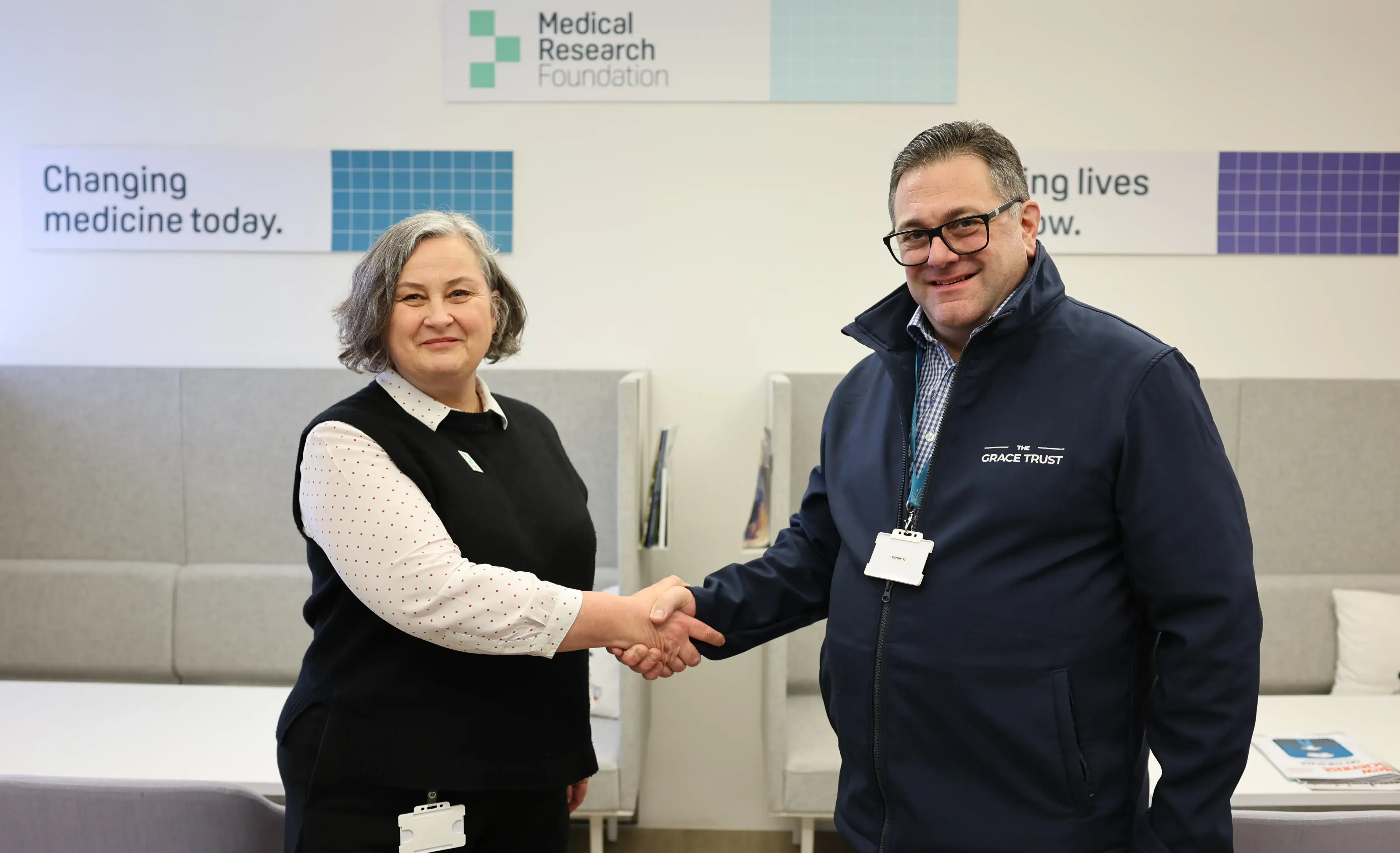Chris Birch, Trust Liaison Manager from the The Grace Trust shakes hands with Dr Angela Hind, Medical Research Foundation CEO