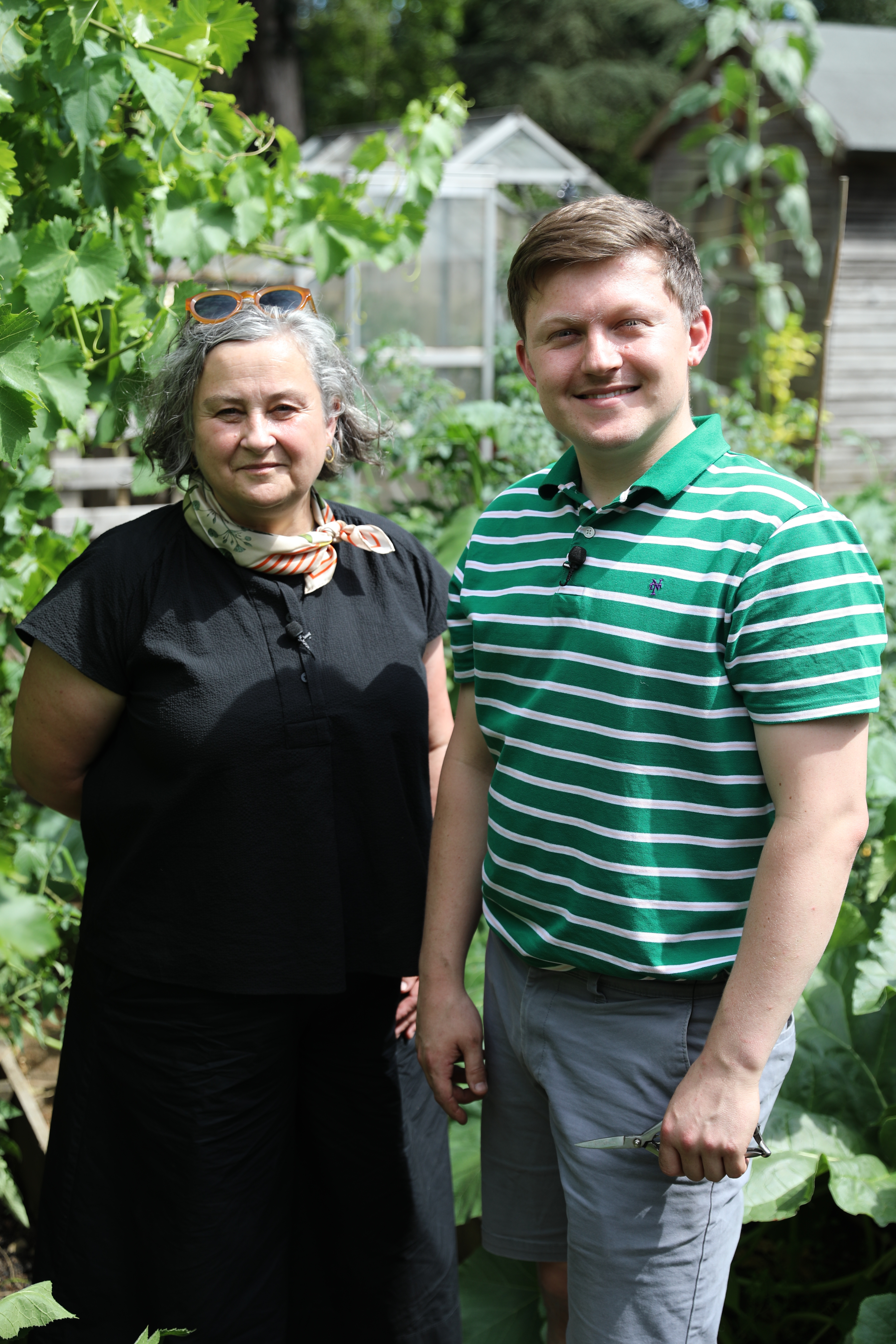 Angela Hind and Josh Smalley in the garden smiling to the camera.