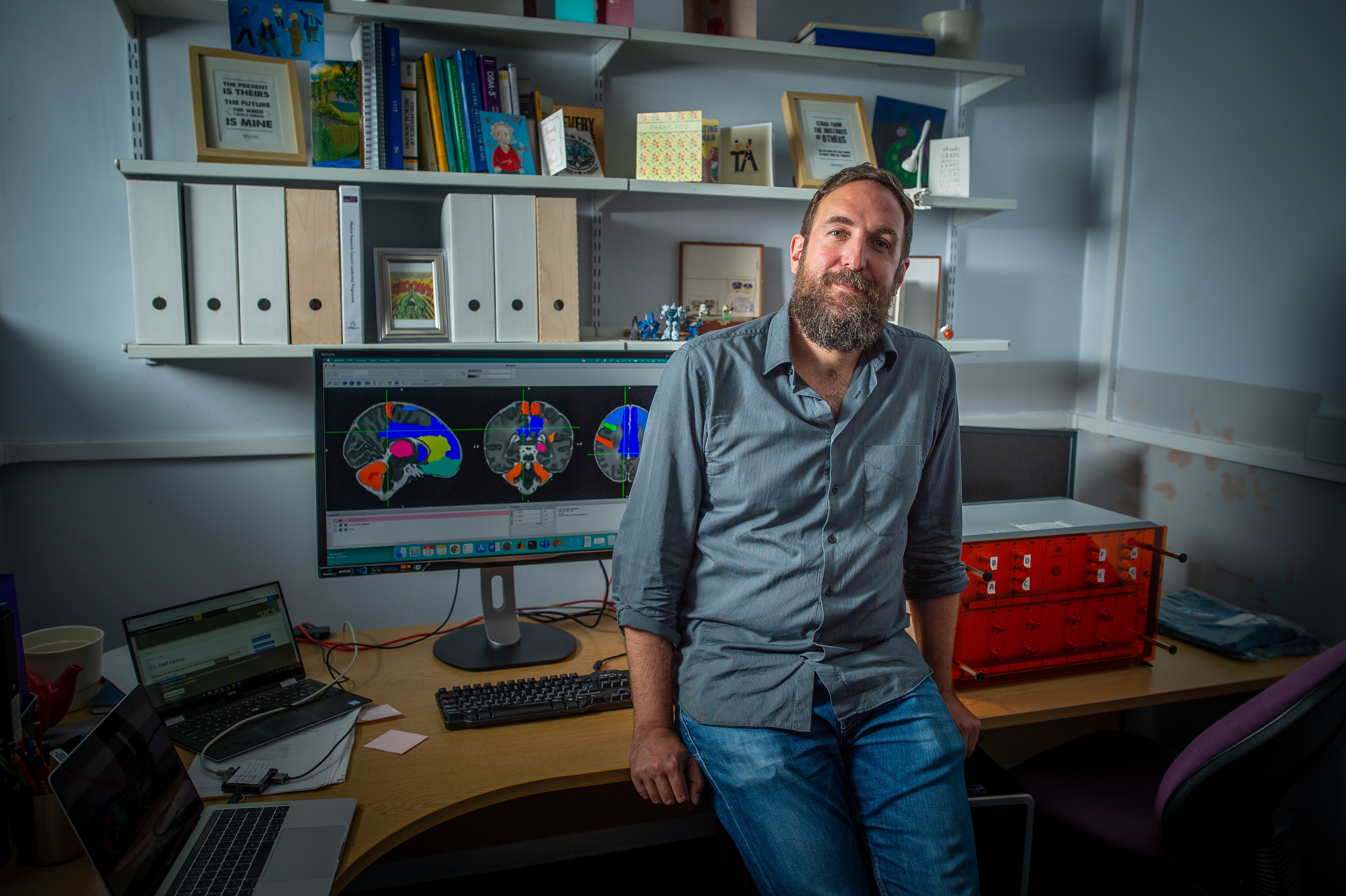 Lorenzo Medical Researcher standing in front of brain scan image