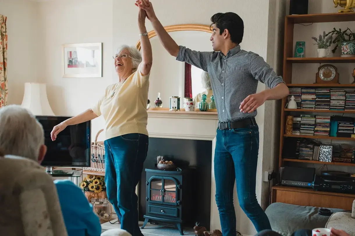Senior Woman Dancing with Grandson at Home